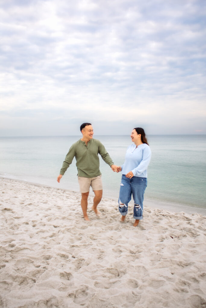 Couple engagement photos on a beach of couple walking together