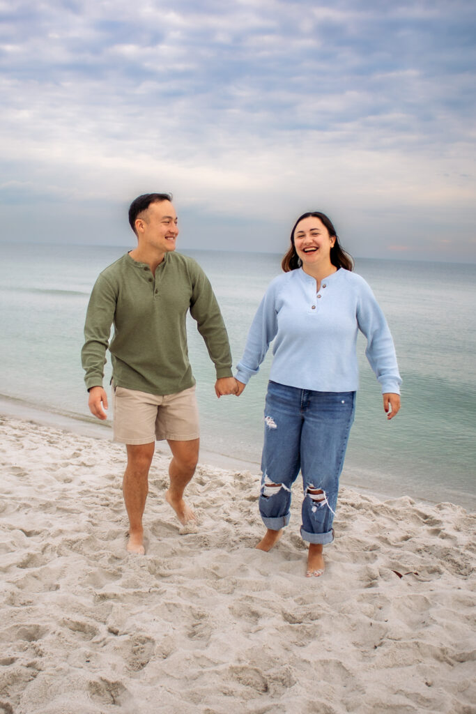 Couple engagement photos on a beach of couple walking together