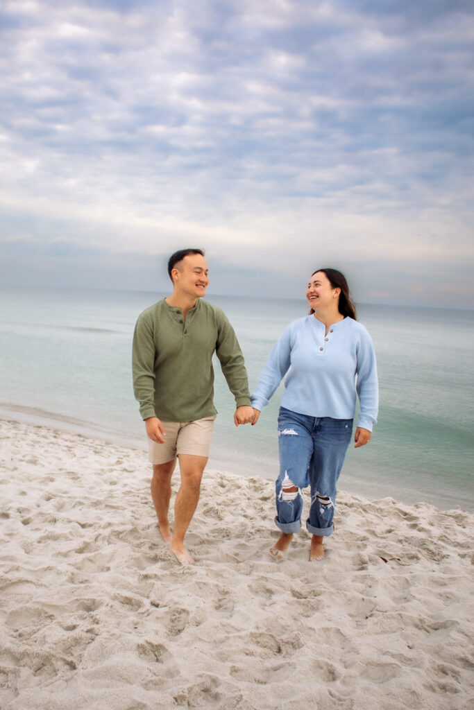 Couple engagement photos on a beach of couple walking together