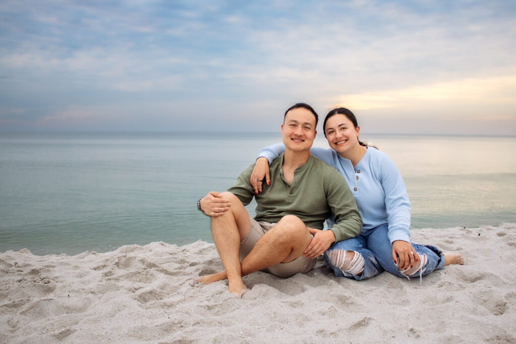 Couple engagement photos on a beach of couple sitting together