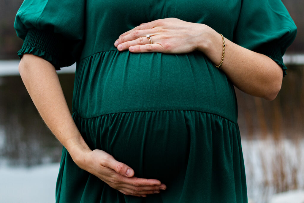 Family maternity portrait closeup with mom holding her belly