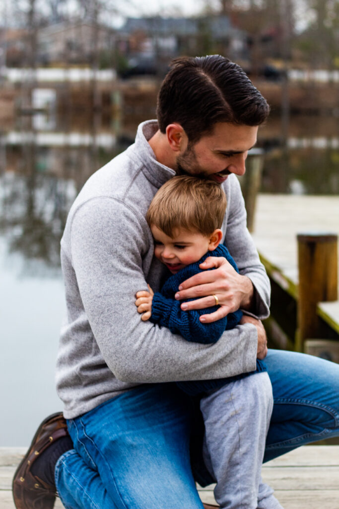 Family maternity portrait of dad hugging toddler.