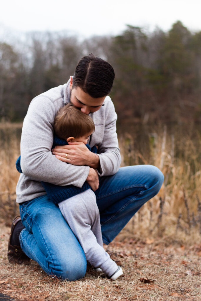 Maternity session family photo with toddler and dad hugging each other